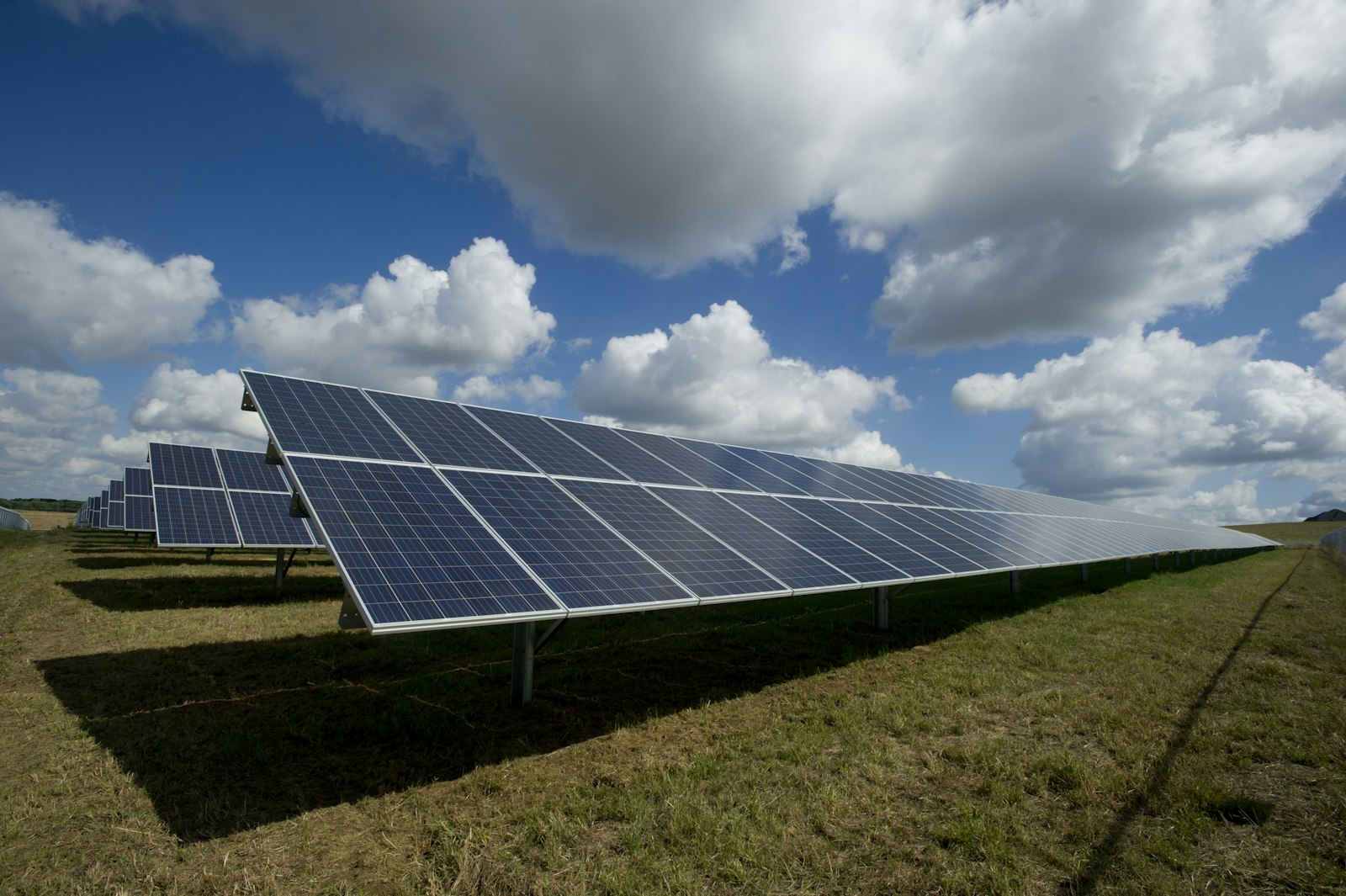 Pannelli fotovoltaici a terra sotto un cielo con nuvole